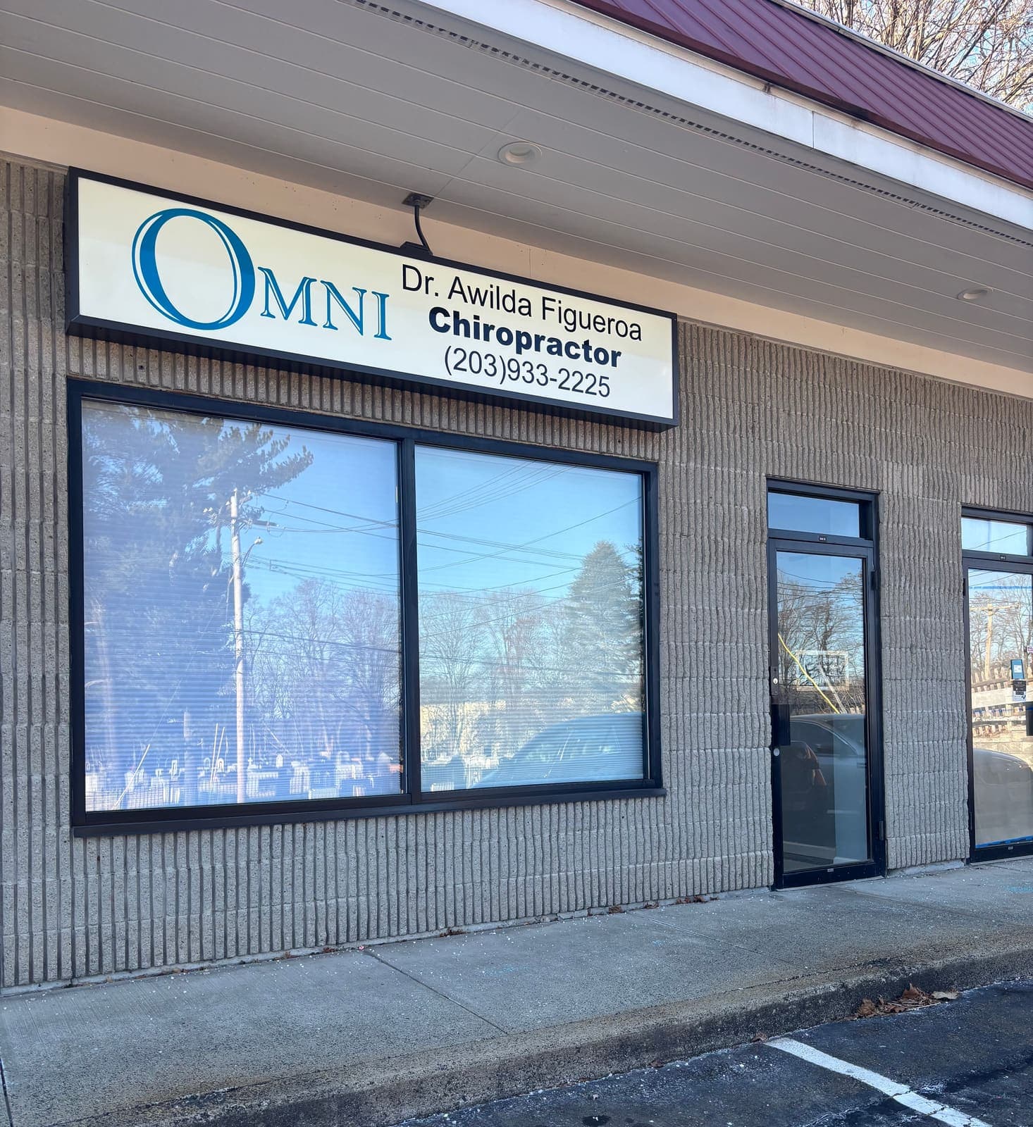 The entrance to Omni's West Haven office at 560 Forest Road, with Dr. Awilda Figueroa's Omni chiropractic sign above the storefront